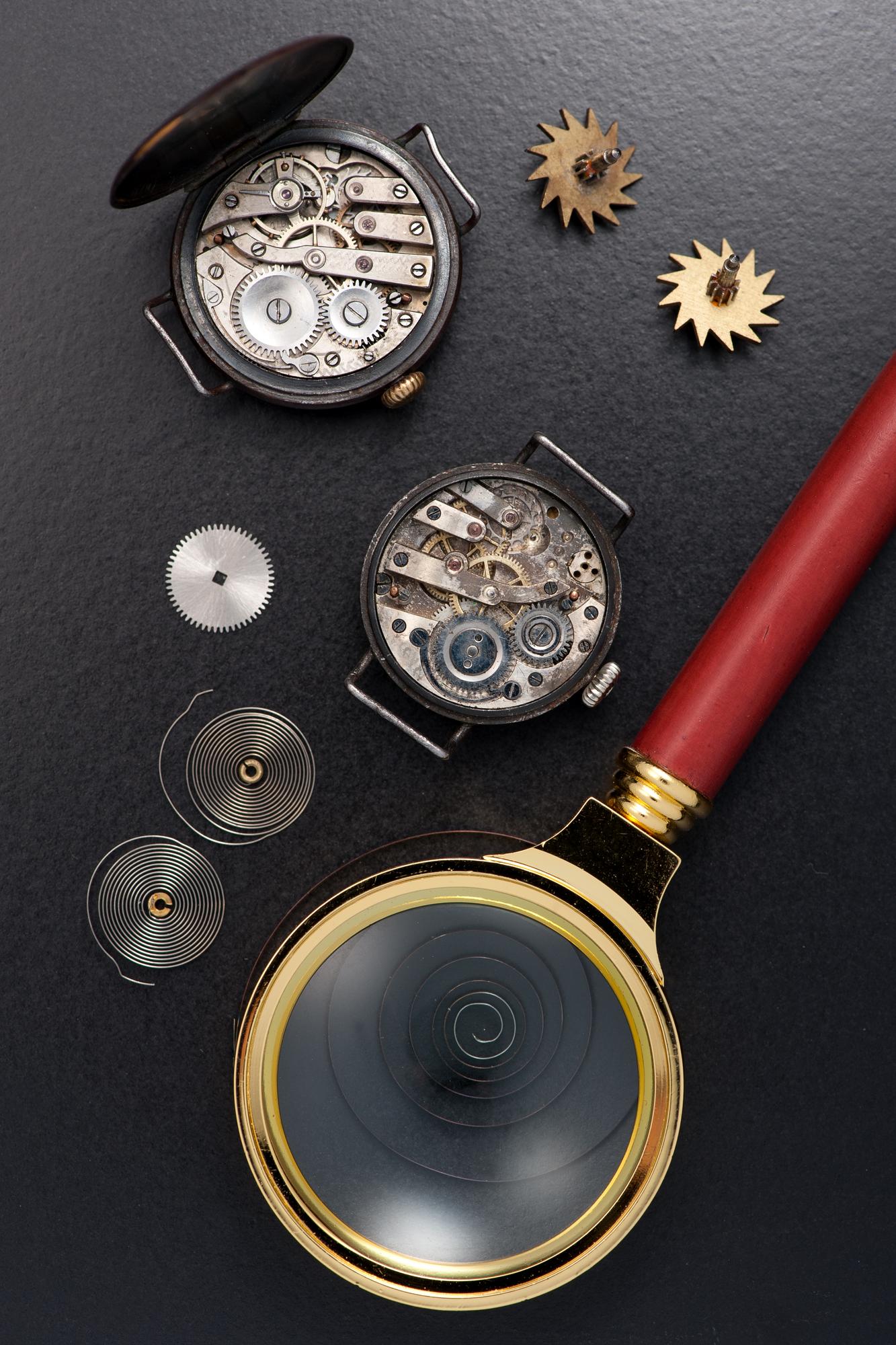Vecchio orologio osservato attraverso una lente di ingrandimento da orologiaio